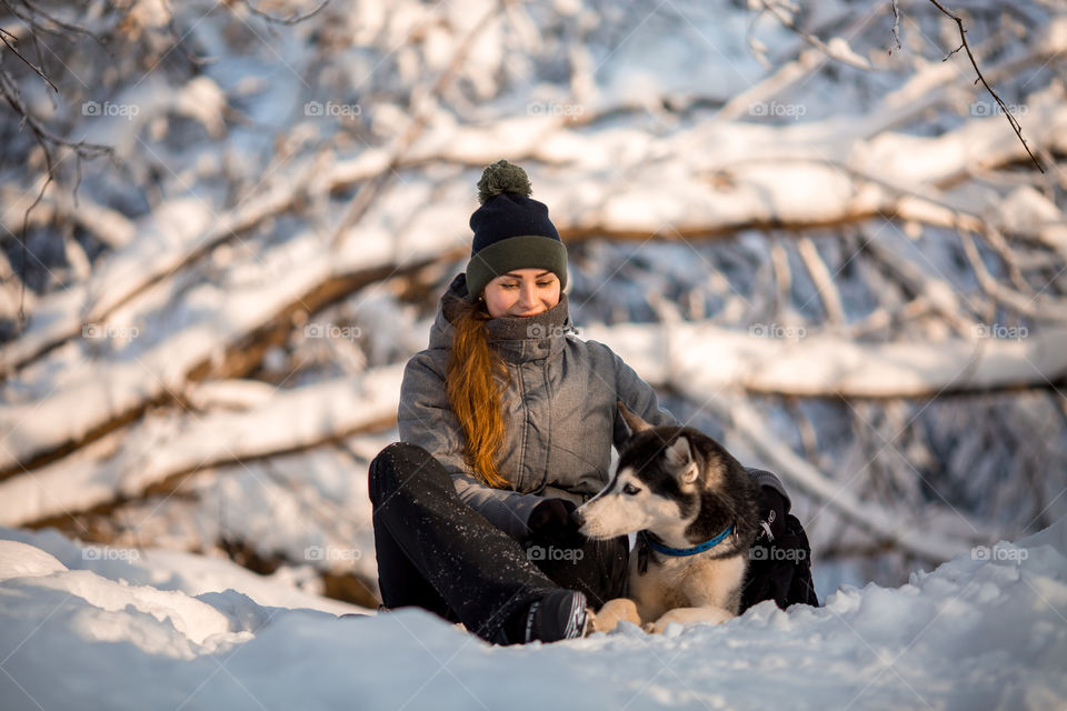 Walking with husky in winter park at sunny cold day