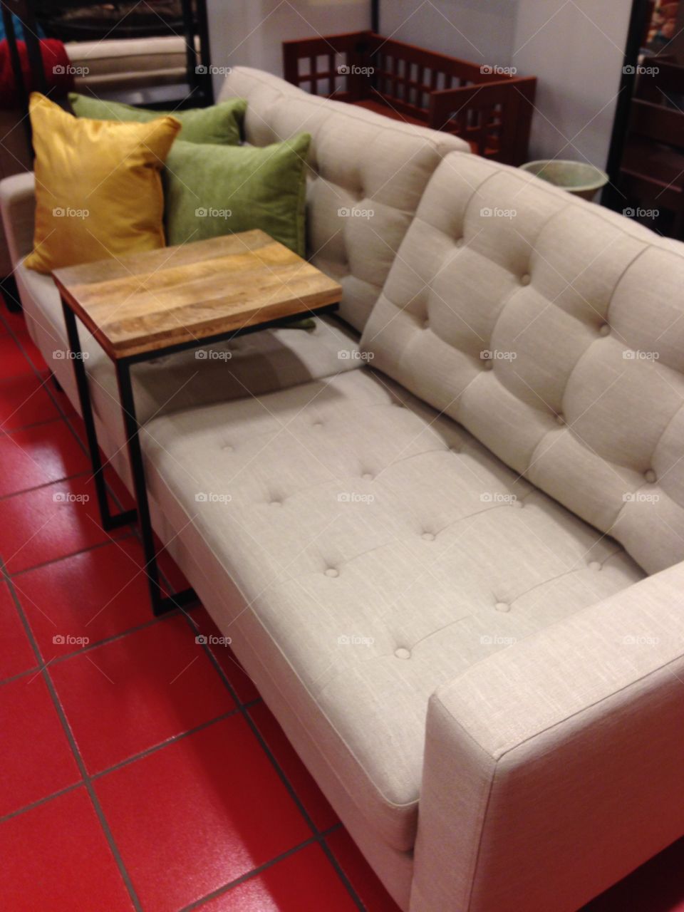 Couch with a TV tray and pillows.