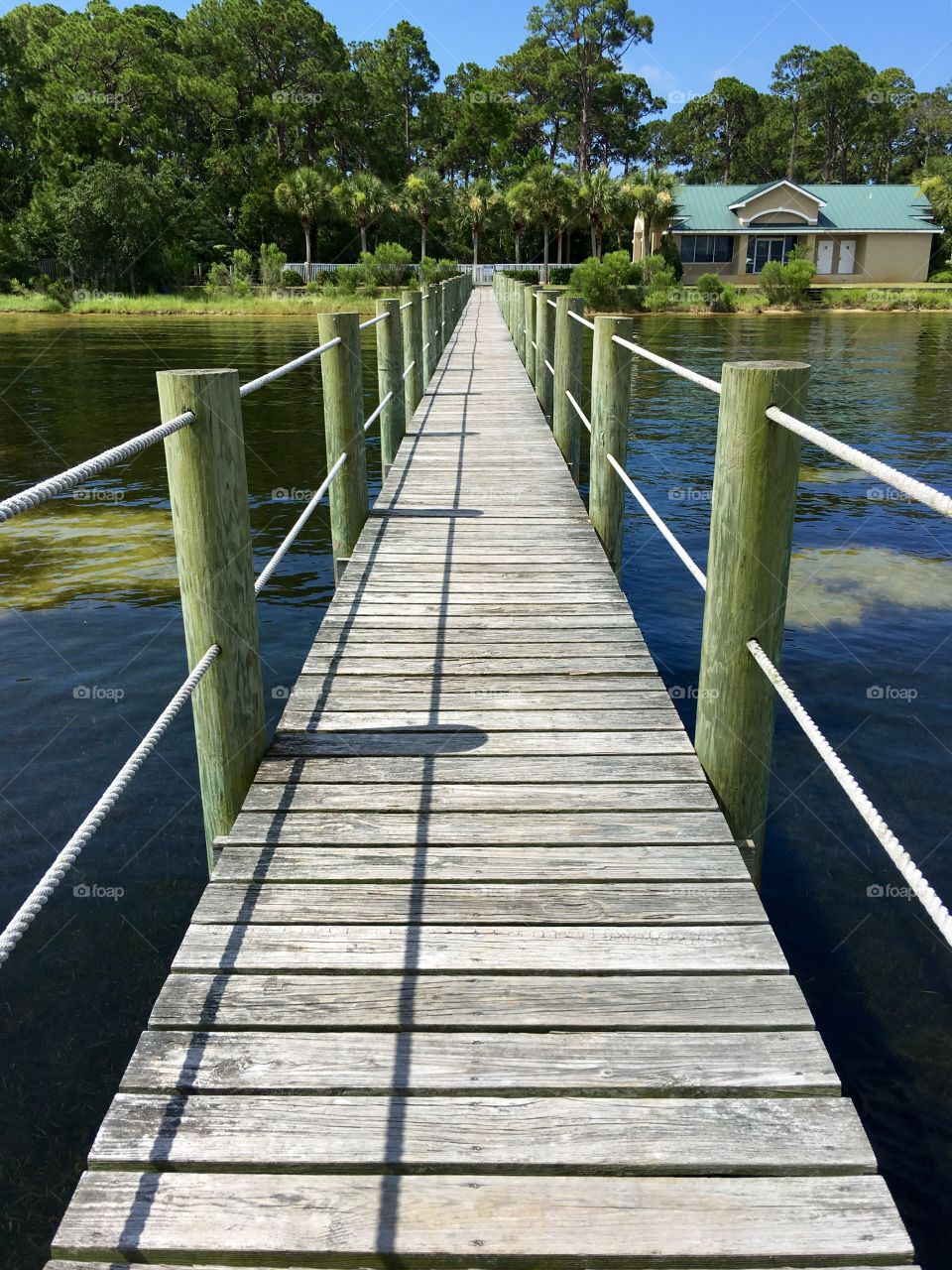 A footbridge over water leading to a house