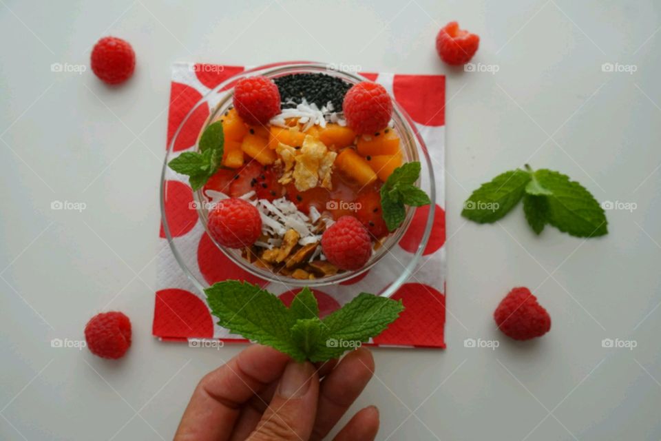 Smoothie fresh fruits bowl - peach, raspberry,  almonds,  strawberries,  coconut,  honey,  seeds and mints