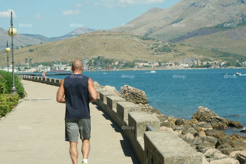 A guy running on seafront