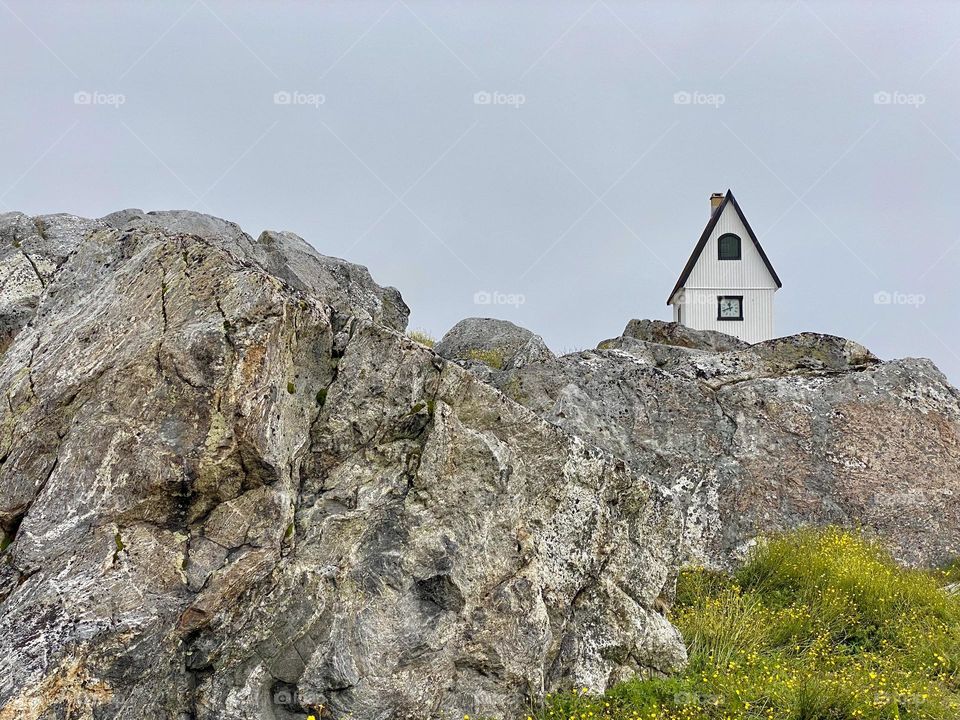 The top of a church just visible above a large rocky outcrop