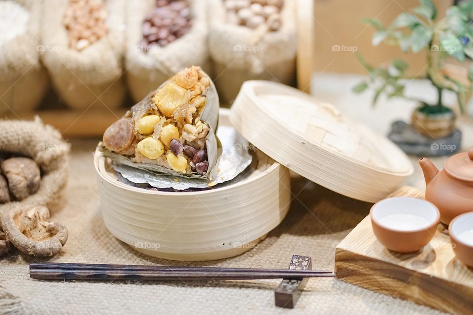 Sticky rice dumpling, soft focus. In Chinese call Zongzi. Zongzi is a traditional Chinese rice dish made of glutinous rice stuffed with different fillings, wrapping in bamboo leaves.