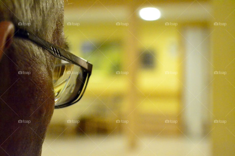 Yellow walls. Old man looking at yellow walls through his Glasses 