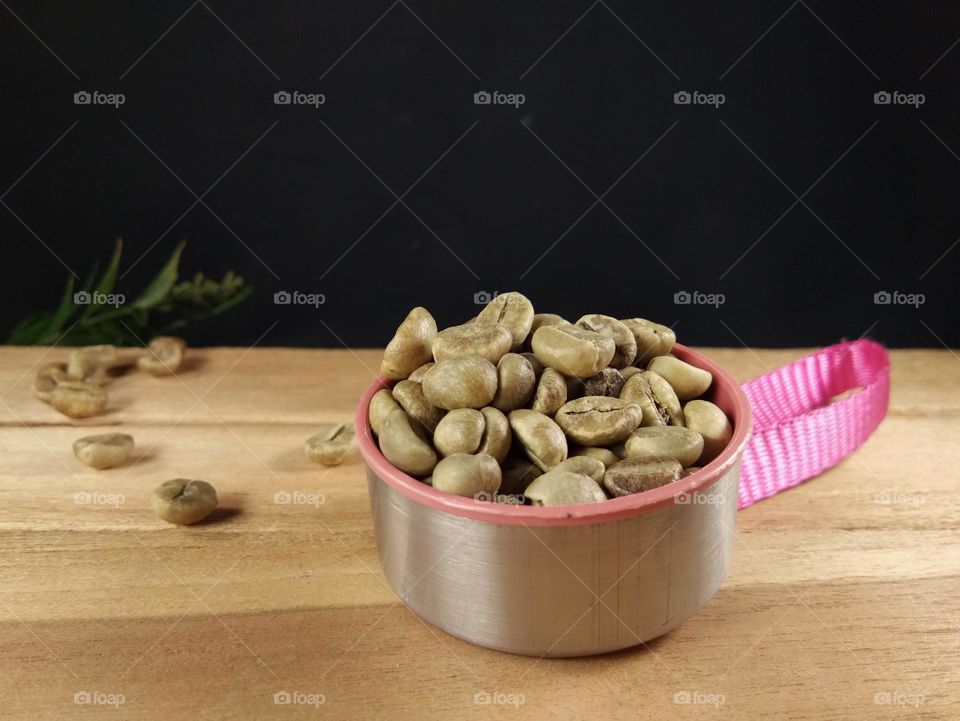 closeup of raw coffee beans on wooden table