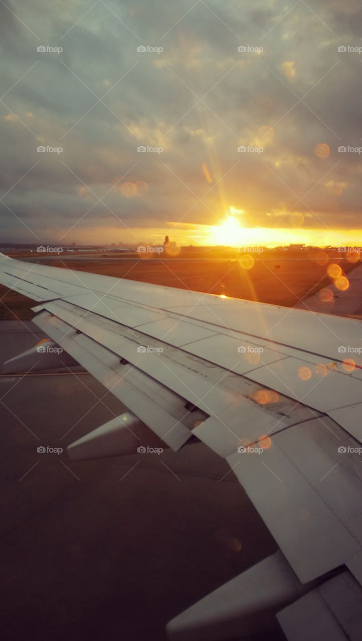 Getting ready for take off as the sun rises above the airplane wing