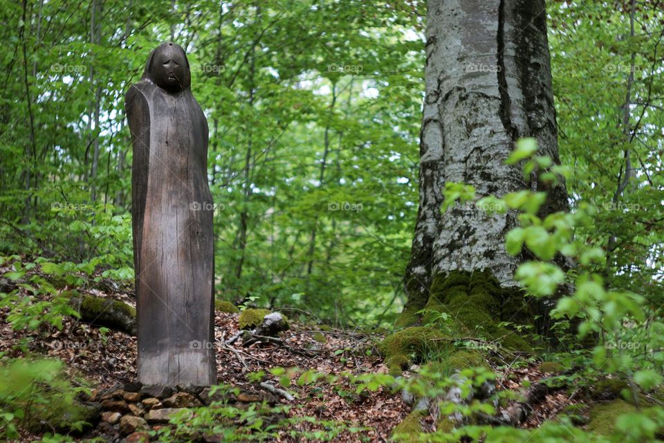 Wooden sculpture in forest