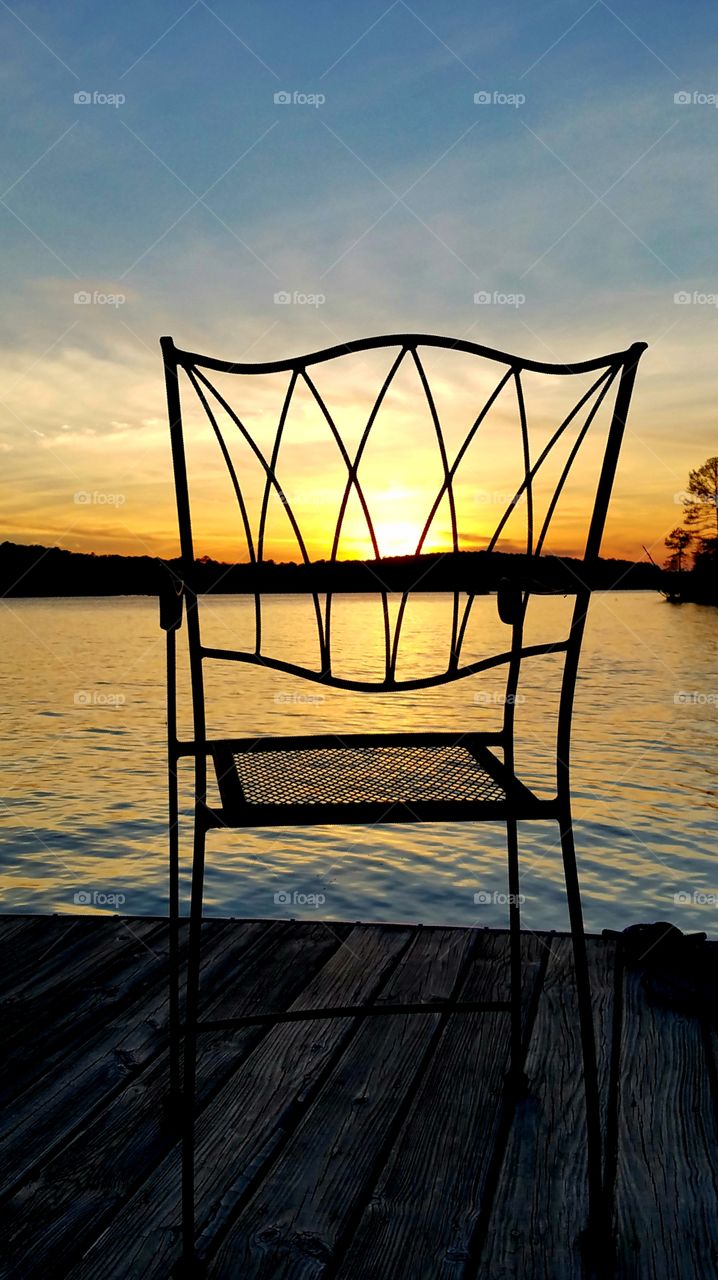 watching the sunset on a dock over the lake.