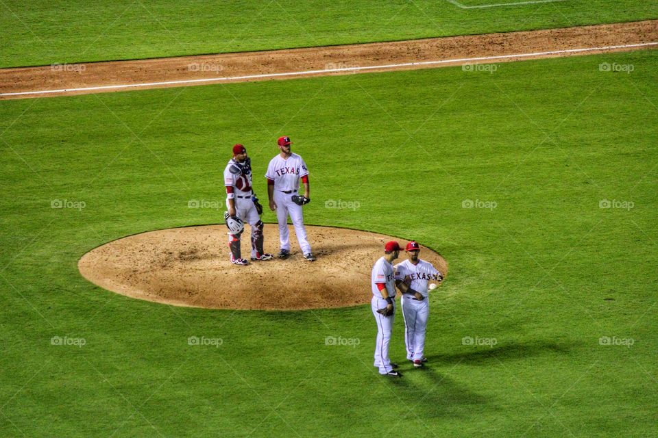 Under review. Baseball players talking on the field while a play is under review