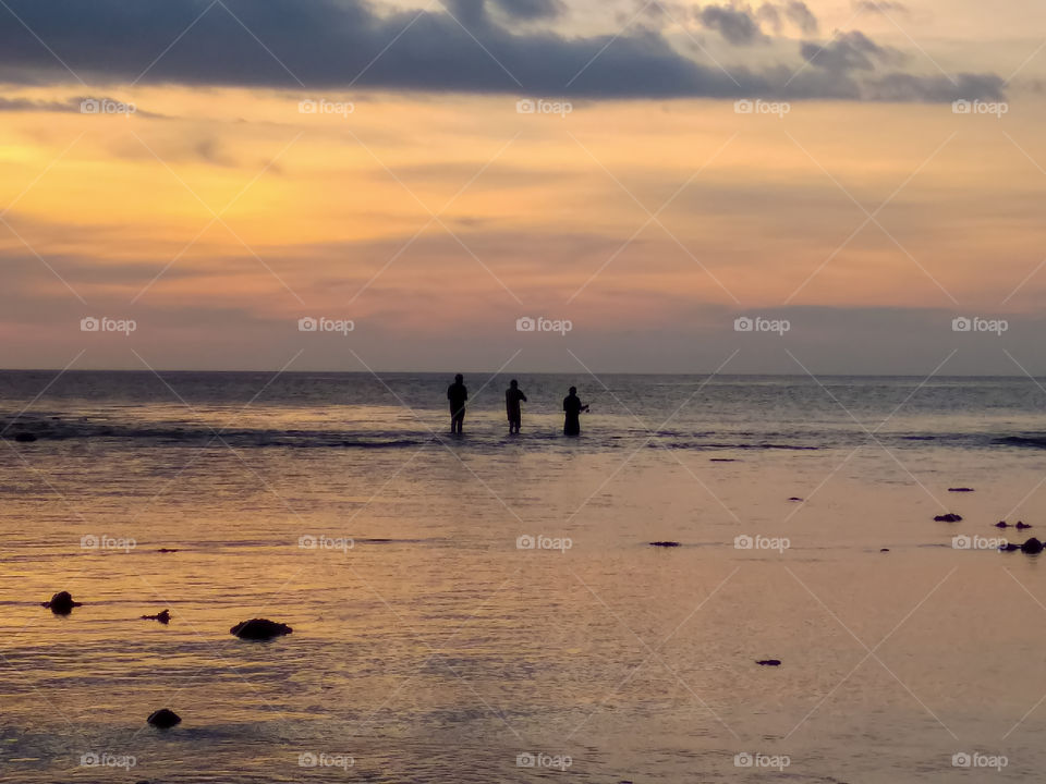 Spending time with friends fishing on beach at vacation