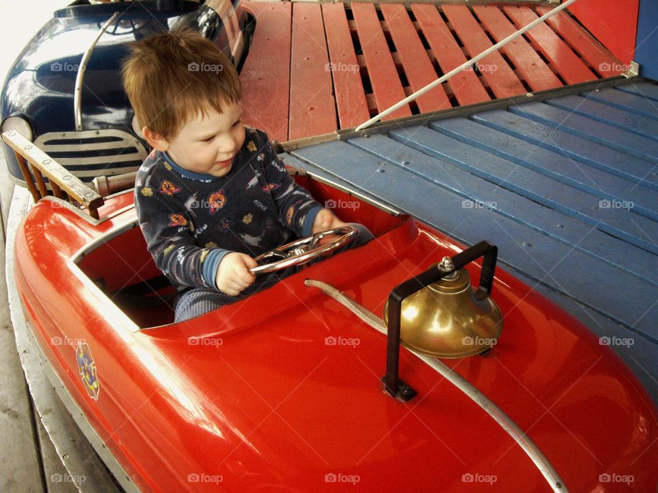 Young Boy Driving A Toy Car