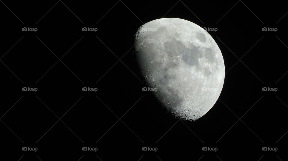 Shinning silvery waxing gibbous moon sole ruler of the night sky closeup craters visible