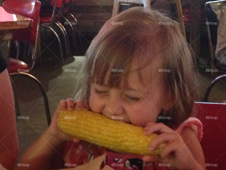 Cuteness overload . Girl eating corn on the cob