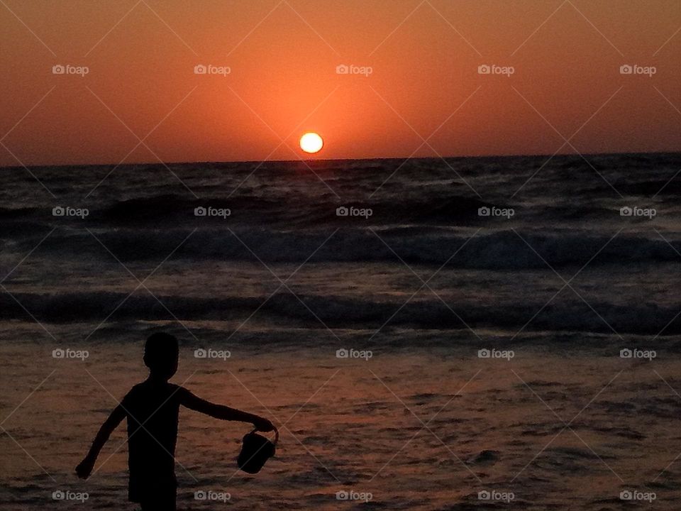 boy still playing on the beach, having fun till the end of the day