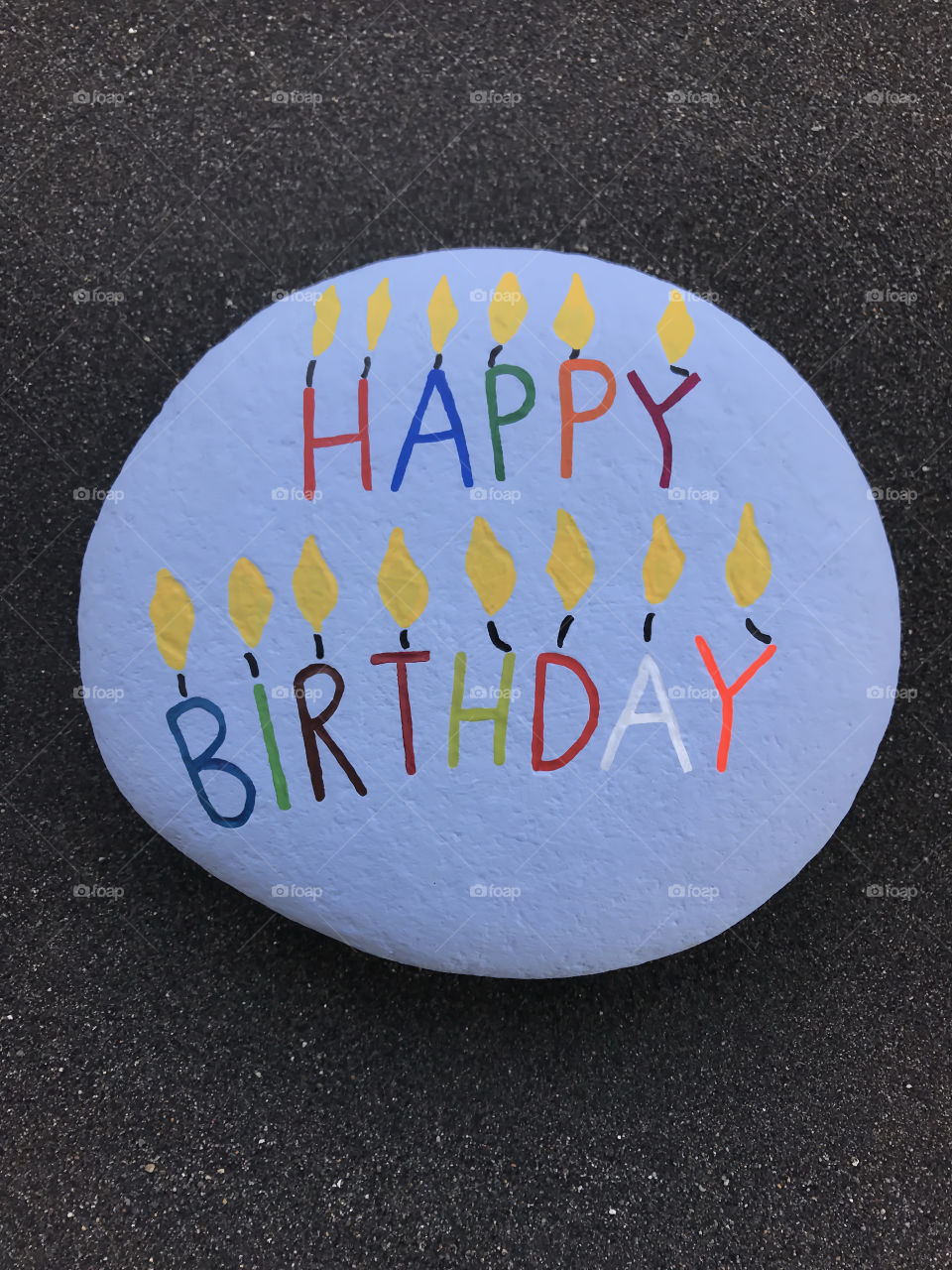 Happy Birthday message on a stone over volcanic sand 