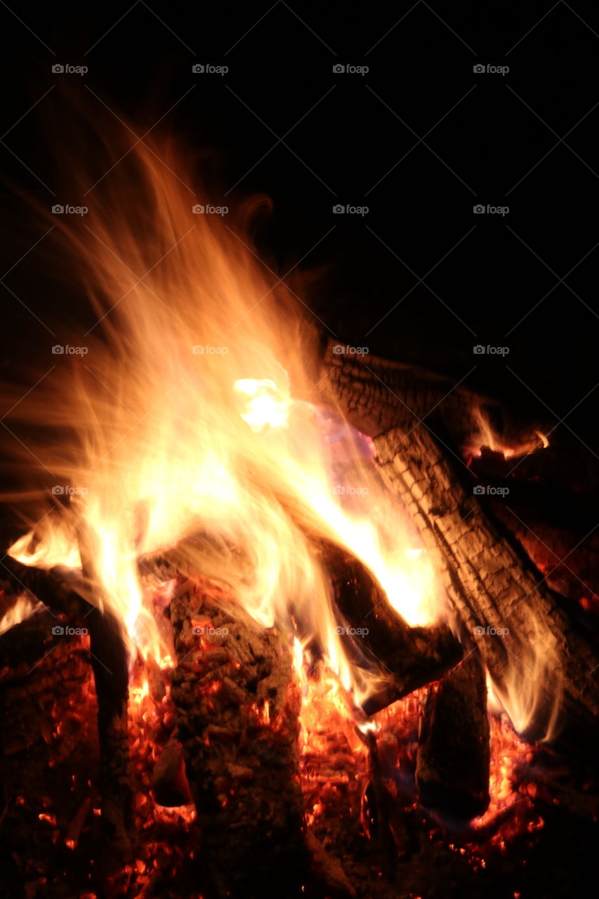 Blazing sparks on a warm campfire.