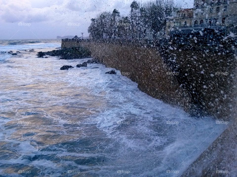 water in motion, wave sea splashing over ancient wall fortification