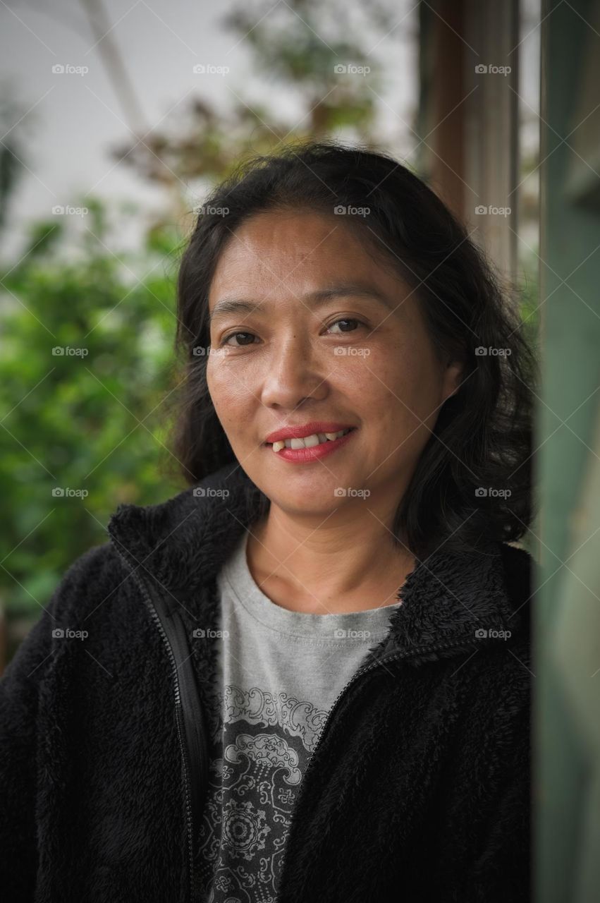 A portrait shot of a Tangkhul Naga woman, feeling happy to be a mother.