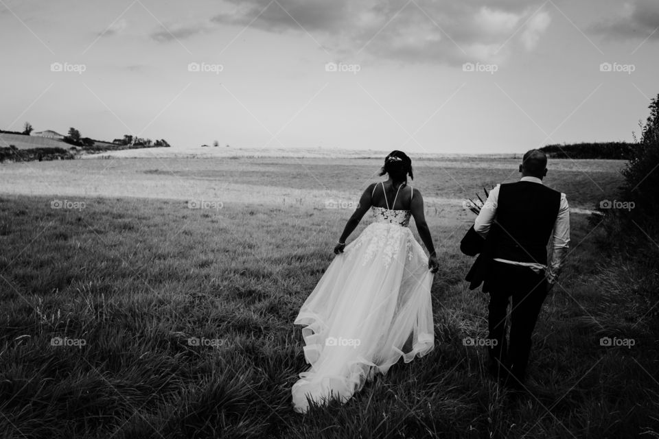 Black and white picture walking around a field on my wedding day.