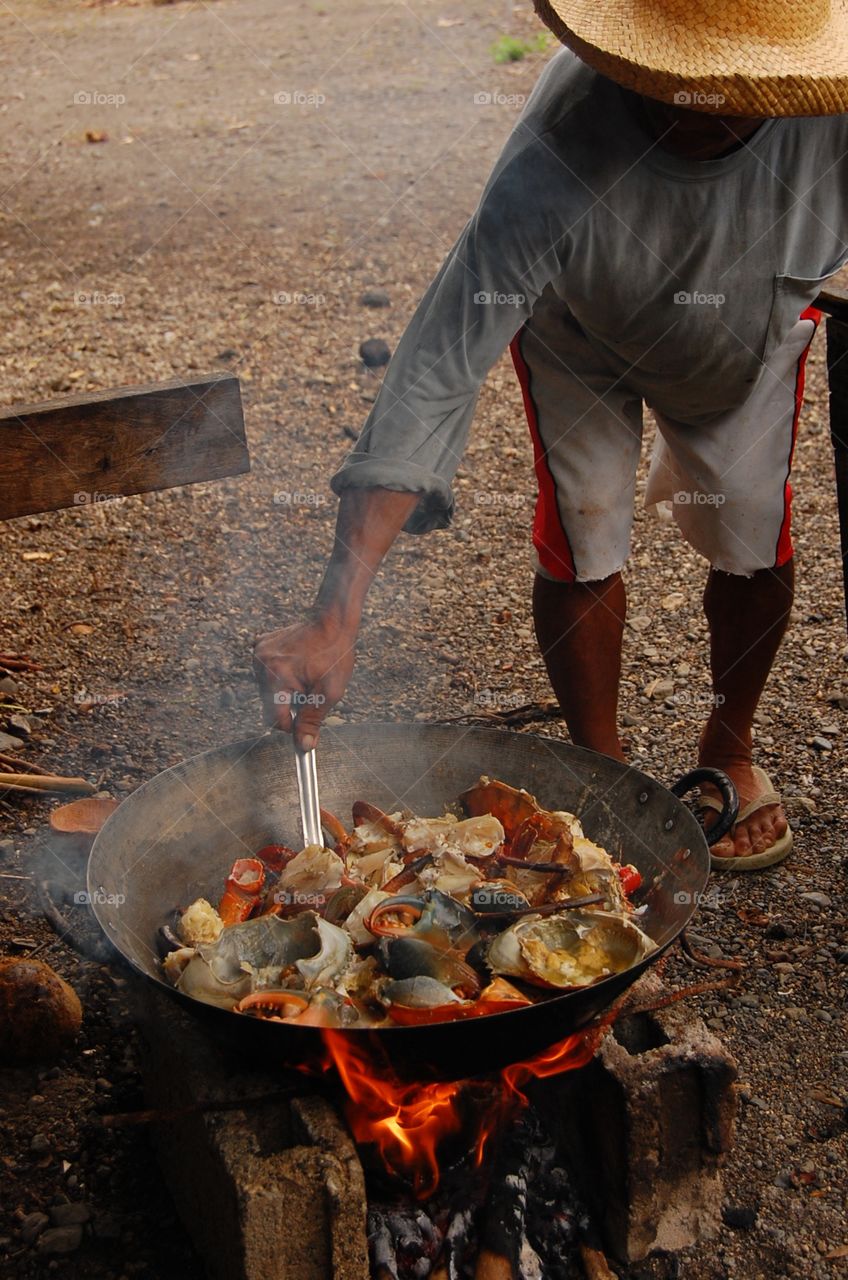 A giant wok and cooking crab with wood fire