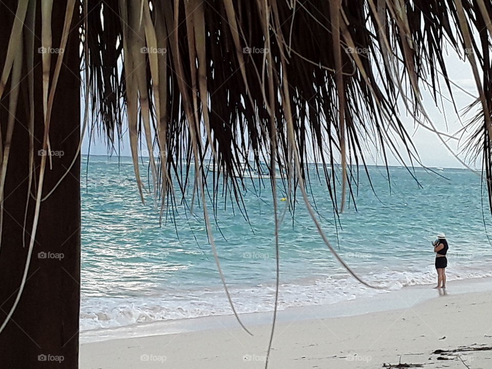 sky ocean beach girl with hat beach canopy made of palm leaves