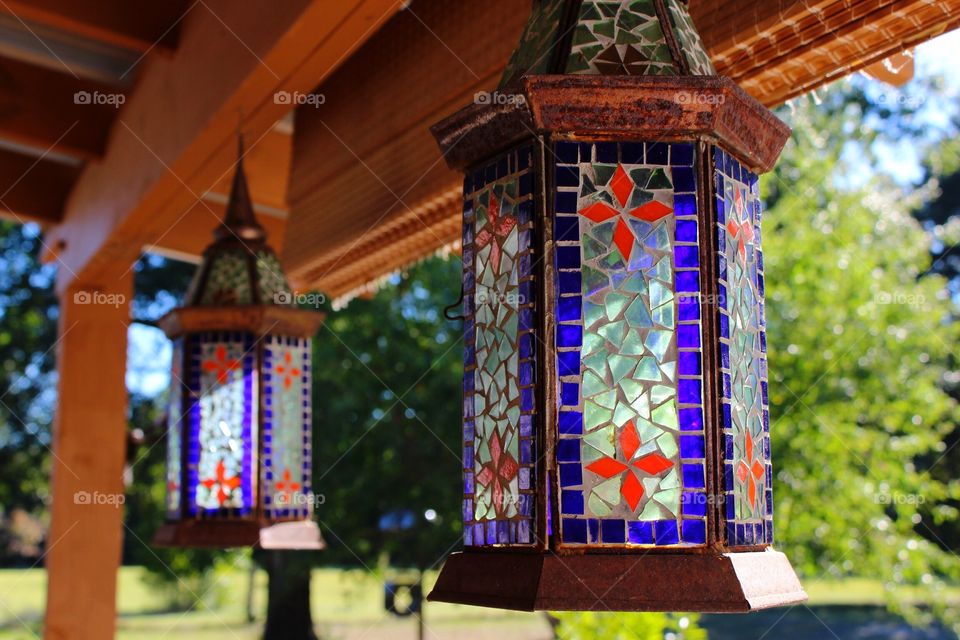 Stained glass candle holders on a back porch 