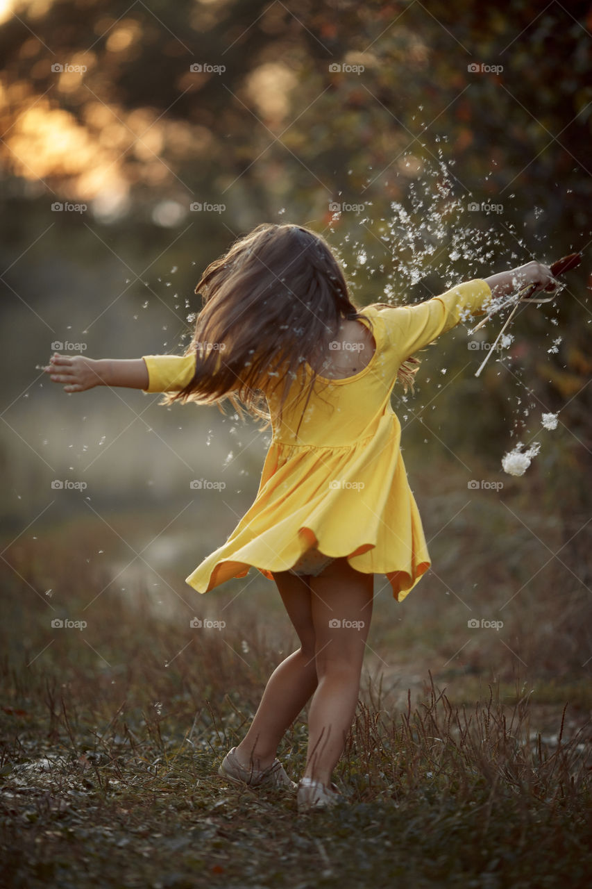 Little girl in yellow dress outdoor portrait at sunset 