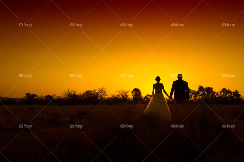 Silhouette image of a couple in the holding hands during an African Sunset. Image from South Africa
