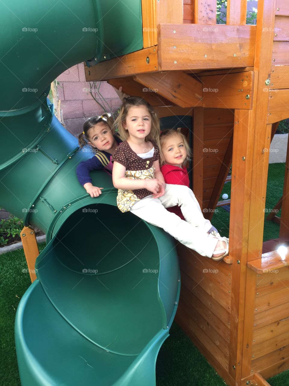 Girls sitting in park on slide