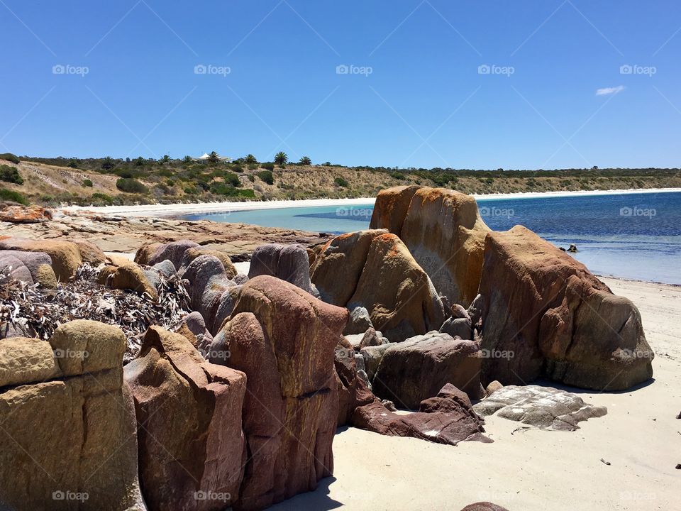 Sand dune cliffs and rocks on remote ocean bay in south Australia shot from ground beach 