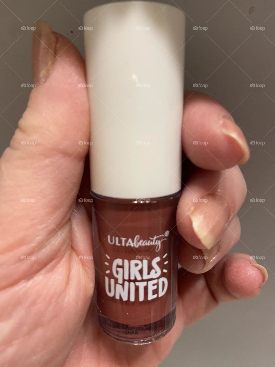 My hand holding Ulta Beauty Girls United Lip Gloss in Unfiltered. This was part of a collaboration with Essence Magazine created by 6 teens through a special mentoring initiative per the information on the package. The kit featured 2 different looks.