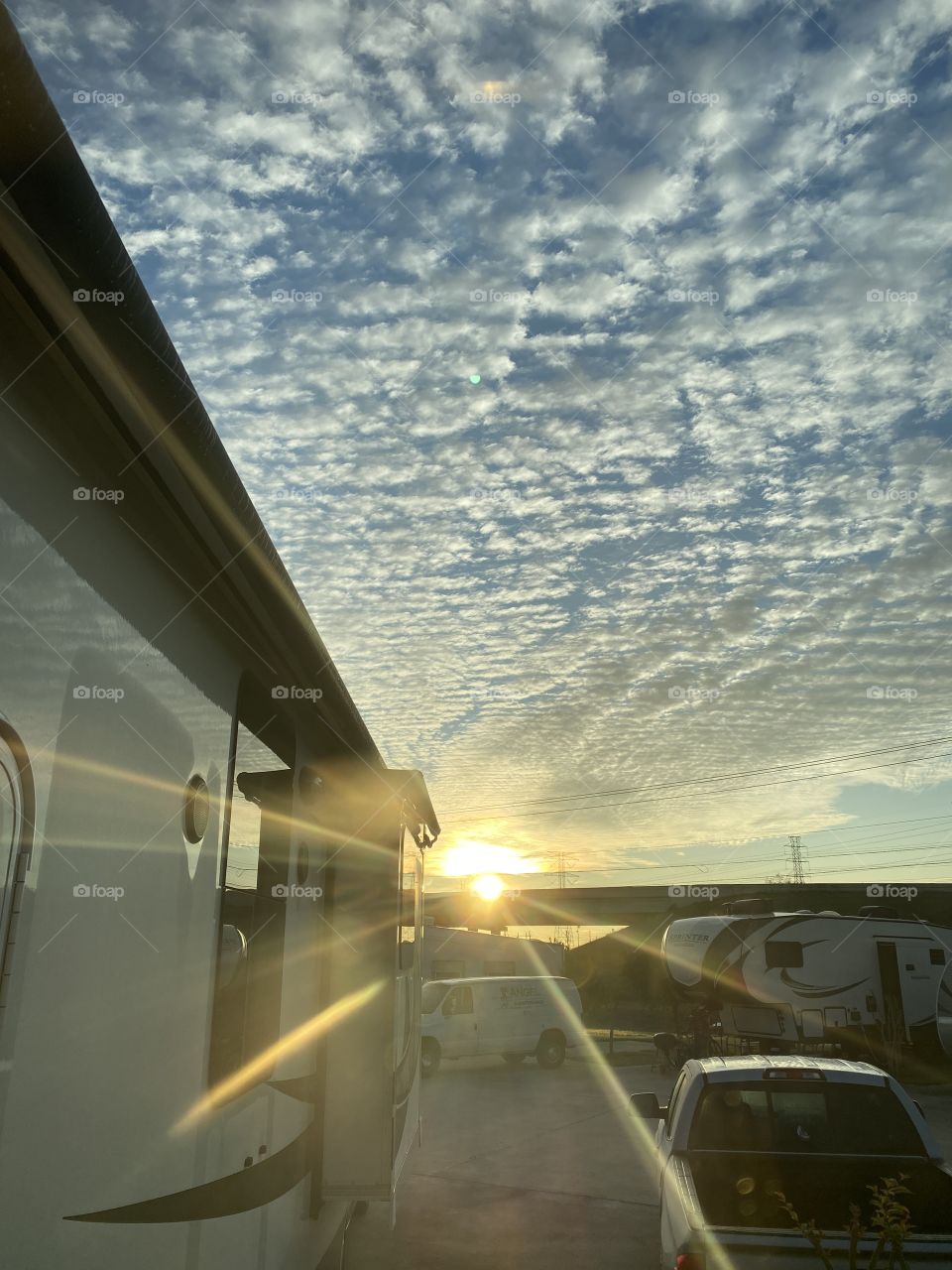 Sunrise With Blanket of High Clouds. Piercing Sun Rise Over transport System Cracks and Splits the Beam of Light. 