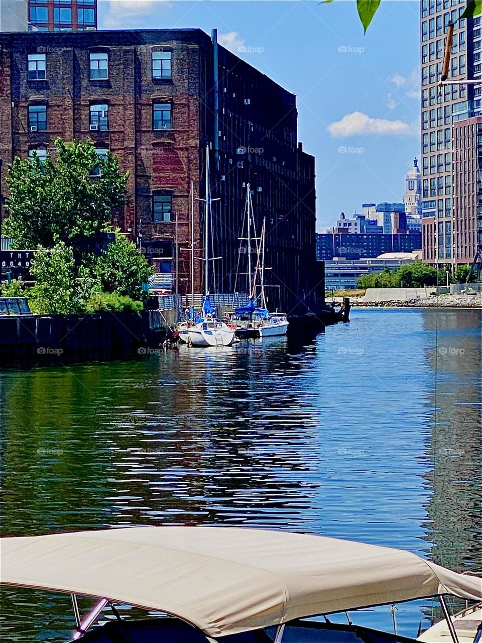 The sailboats across the „East River“ at „Newtown Creek“ are tied to the „Greenpoint“, Brooklyn side of the creek. The ocean today is smooth and still, hardly a ripple goes across it. 2023. Hypnotic Productions