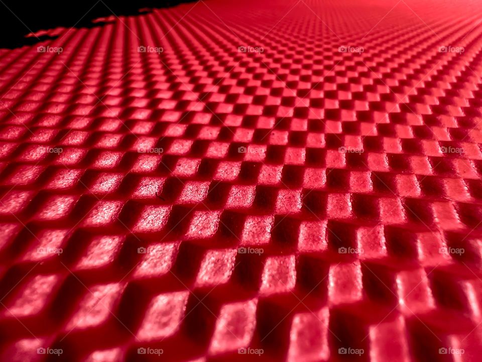 Close up of exercise mat with repeating cubic/square patterns from the nonslip surface