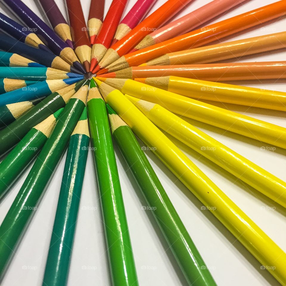 Colorful pencils arranging on white background