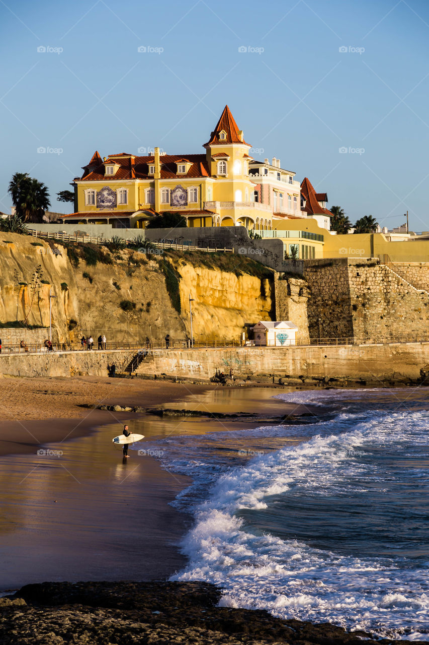 Surfer's beach, beautiful beach surrounded by cliffs and a mansion/palace on top, beautiful water reflections