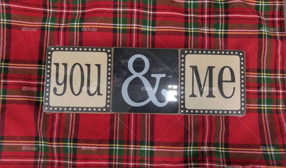 A sign that says you & me against a plaid background