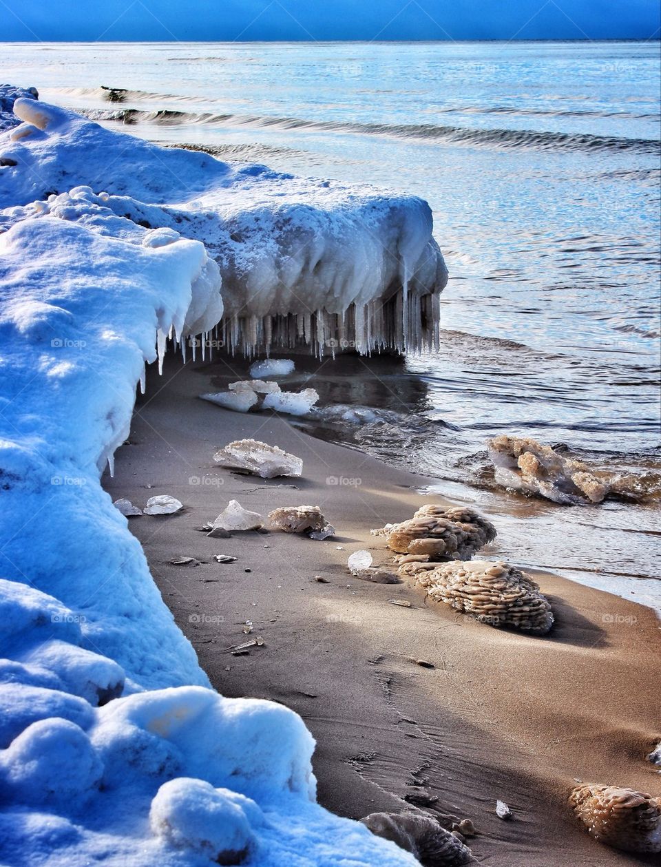Icicles and snow on winter beach