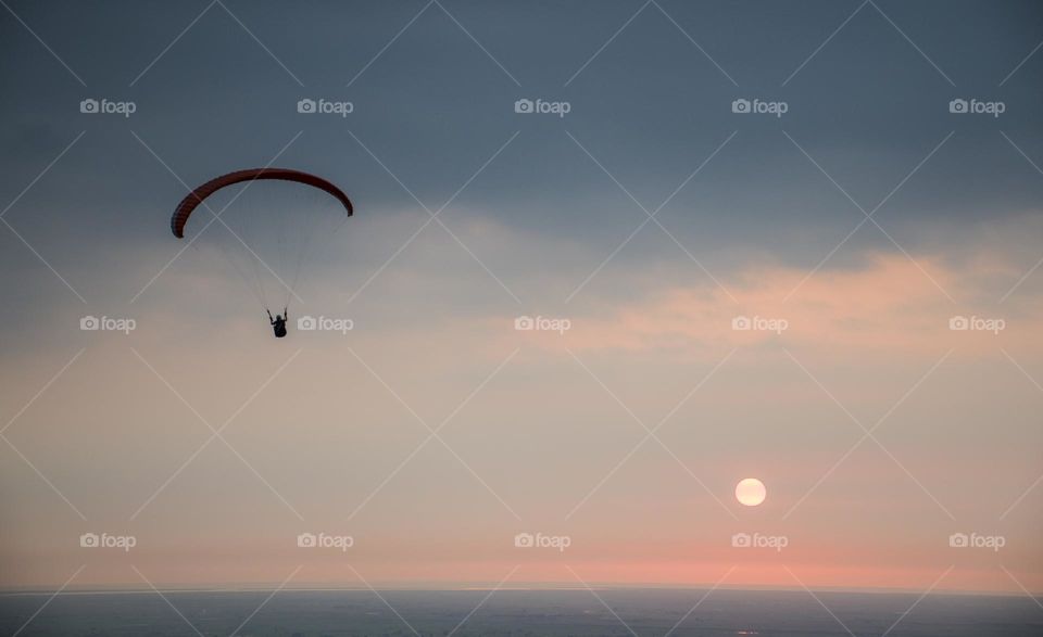 Paragliding flight next to sunset
