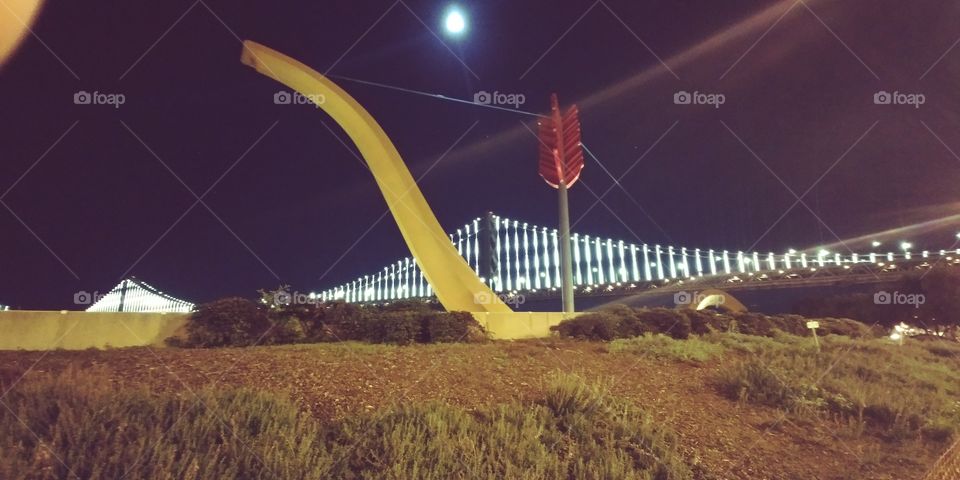 bow and arrow sculpture in front of Bay Bridge