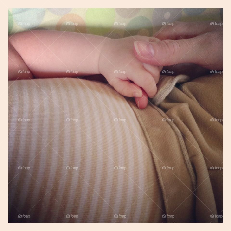 Baby holding women's hand