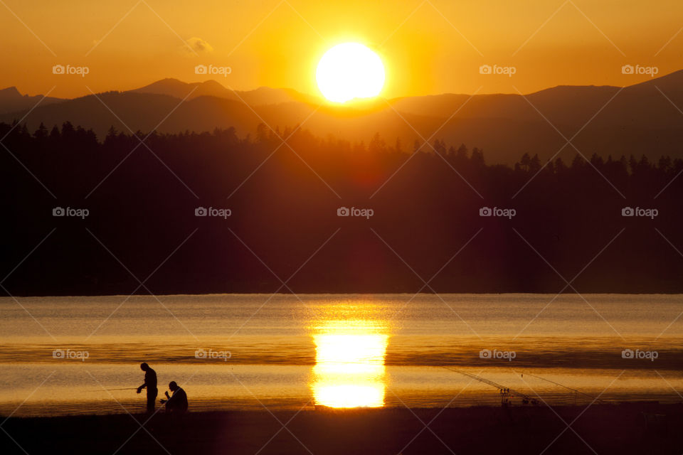 Fishermans near high mountain Bulgarian Batak dam lake, sunset view