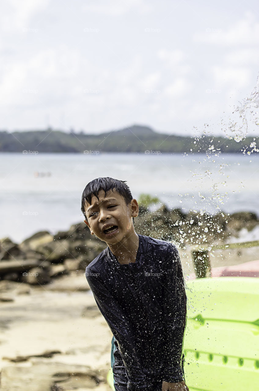 Asian boy wearing a swimsuit and shower Background sea.