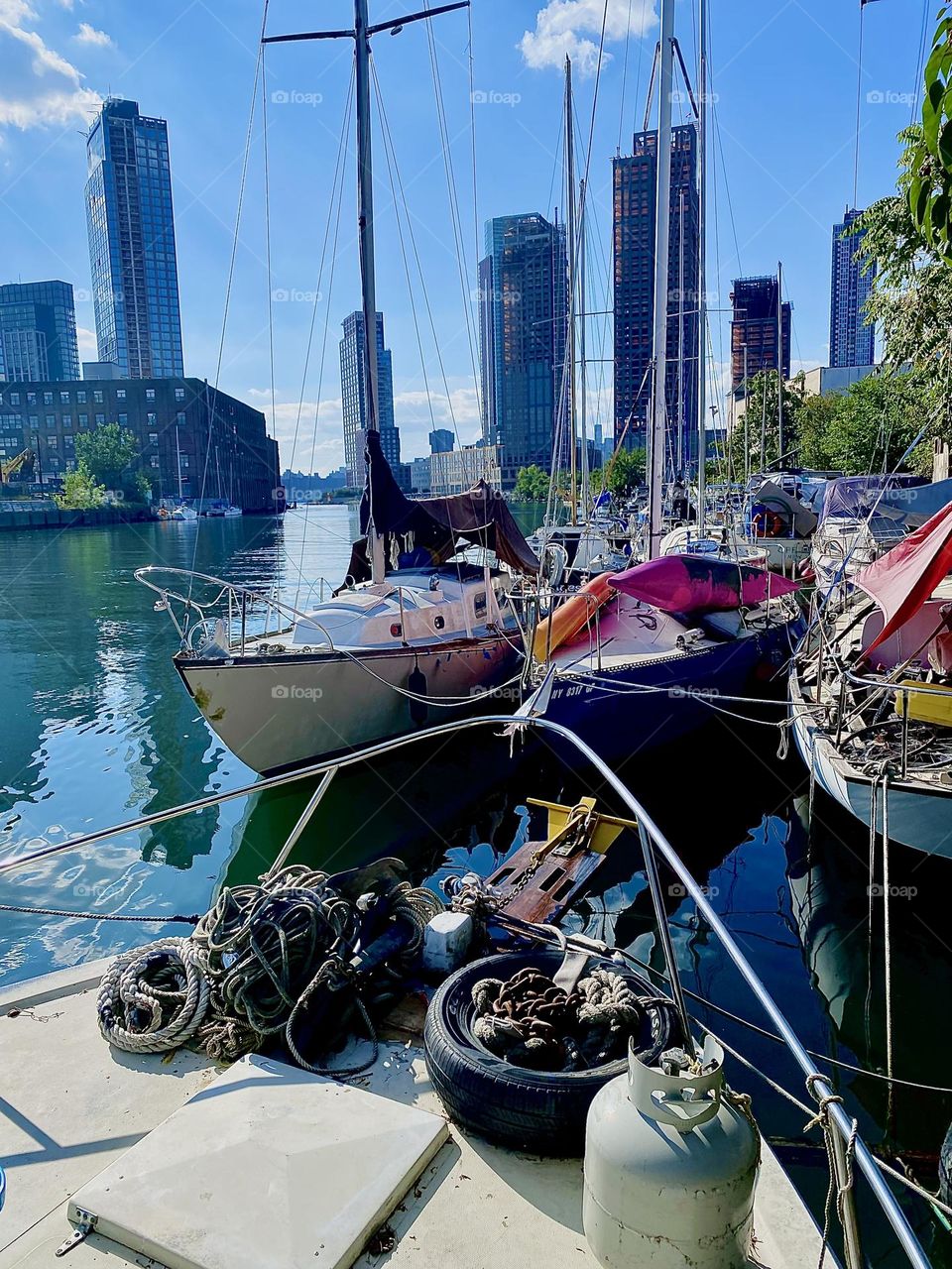 These boats are tied to the shore at „Newtown Creek“ by the „Pulaski Bridge“ in LIC, Queens. They were photographed from aboard „Salvation“, the „28 ft 1969 Luhrs“ cabin cruiser we call home on a bright sunny day in October 2023. Hypnotic Productions