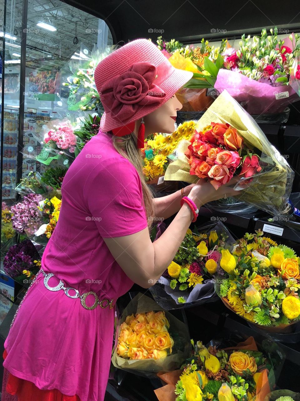 Woman shopping for flowers in a magenta dress.