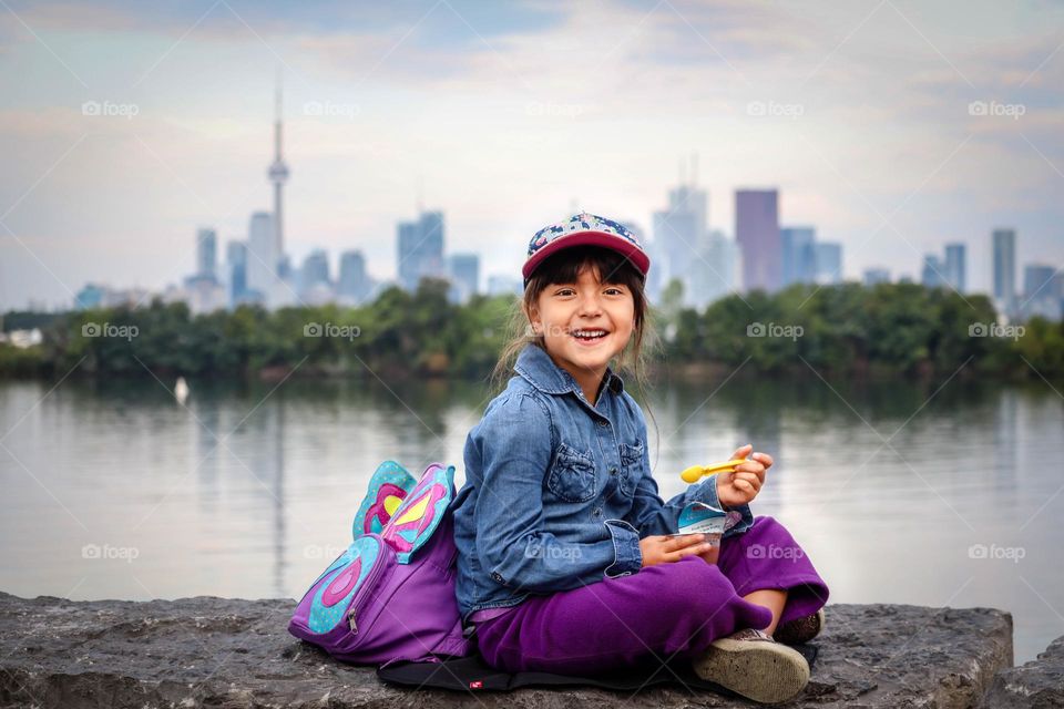 Cute little girl is snacking outdoors