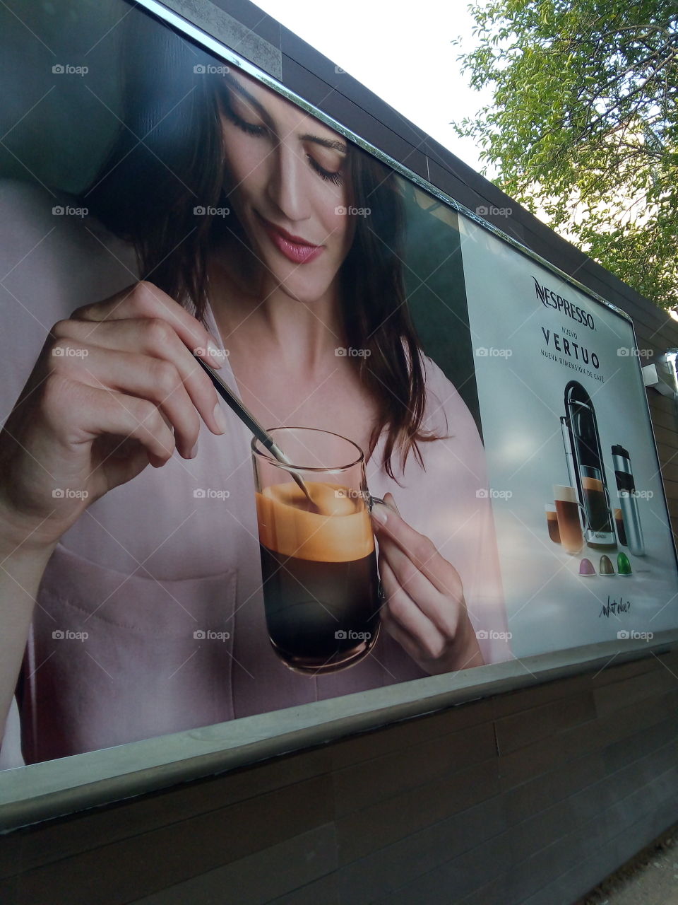 anuncio en pared de publicidad donde se aprecia una mujer tomando café.