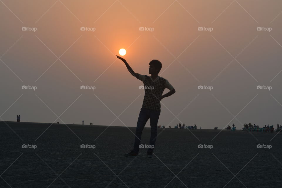 Silhouette of a man holding sun