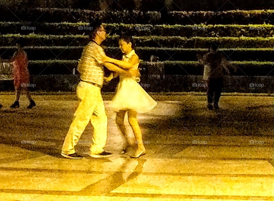 The memories of summer: ballroom dancing night club outdoor activity. dancer's graceful posture in the dark light that was very attractive. it was a beautiful memory of summer in my heart.