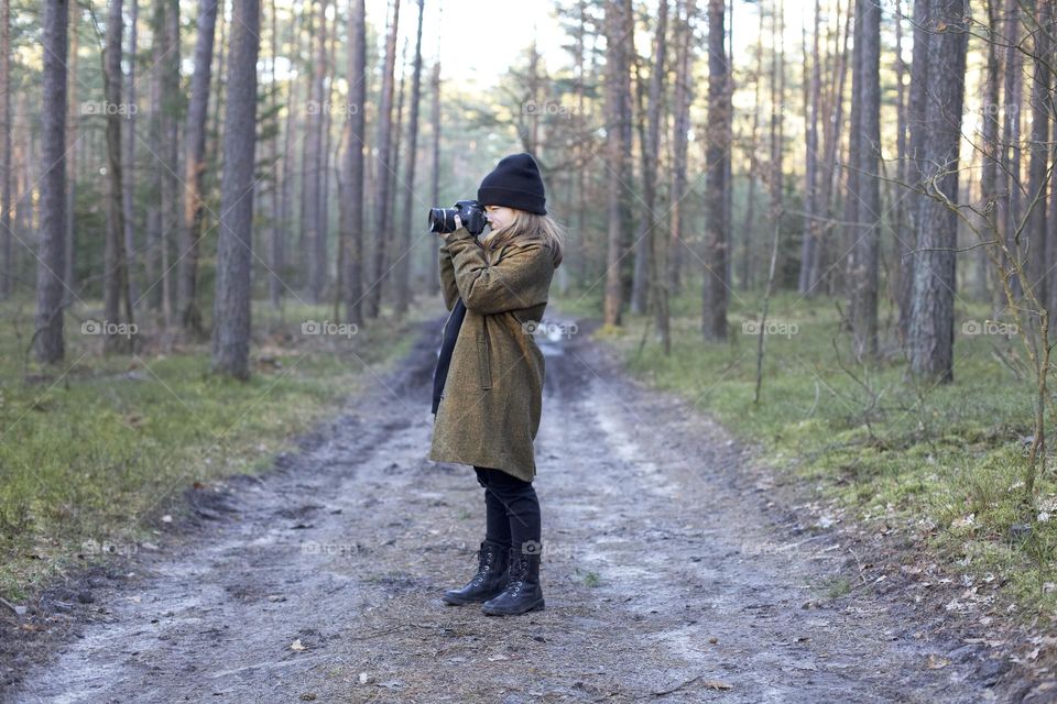 Young girl making photo in the forest